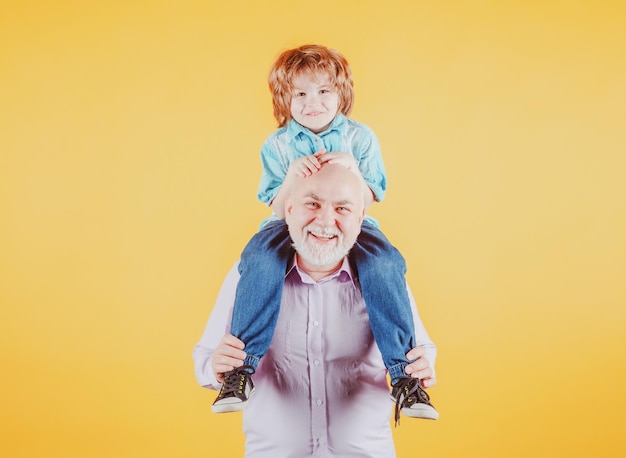 Grootvader en kleinzoon op de rug rijden met grappig gezicht geïsoleerd Oudere oude familielid met kind