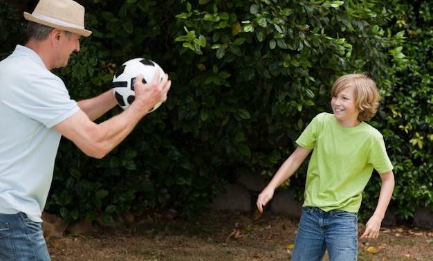 Grootvader en zijn kleinzoon voetballen