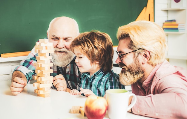 Grootvader vader en zoon spelen binnenshuis grootvader vader en leerling zoon lachend tegen thuis bac