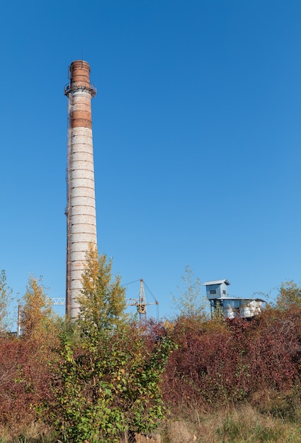 Grote bakstenen schoorsteen. Hoge fabrieksschoorsteen gemaakt van baksteen tegen blauwe lucht