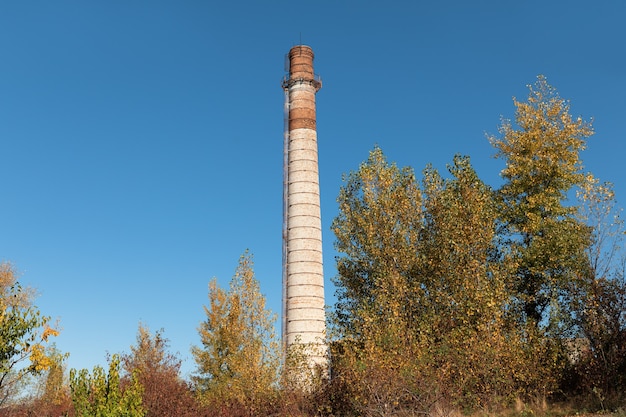 Grote bakstenen schoorsteen. Hoge fabrieksschoorsteen gemaakt van baksteen tegen blauwe lucht