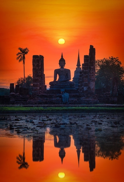 Grote Boeddha bij zonsondergang in Wat Mahathat tempel, Sukhothai Historical Park, Thailand.