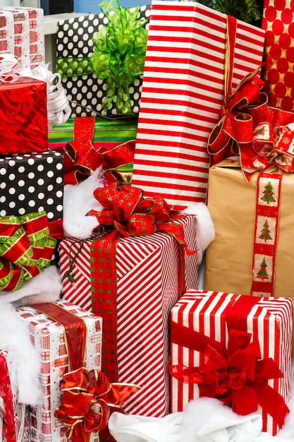 Grote cadeautjes verpakt in kleurrijke papieren met strikken in een stapel klaar voor Kerstmis.