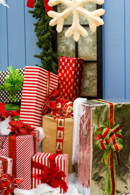 Grote cadeautjes verpakt in kleurrijke papieren met strikken in een stapel klaar voor Kerstmis.