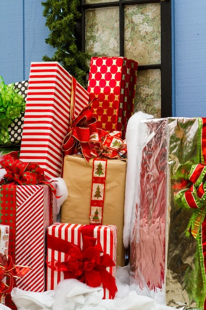 Grote cadeautjes verpakt in kleurrijke papieren met strikken in een stapel klaar voor Kerstmis.