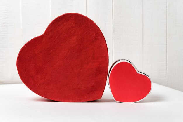 Grote en kleine rode hartvormige dozen op tafel. Zijaanzicht. Valentijnsdag