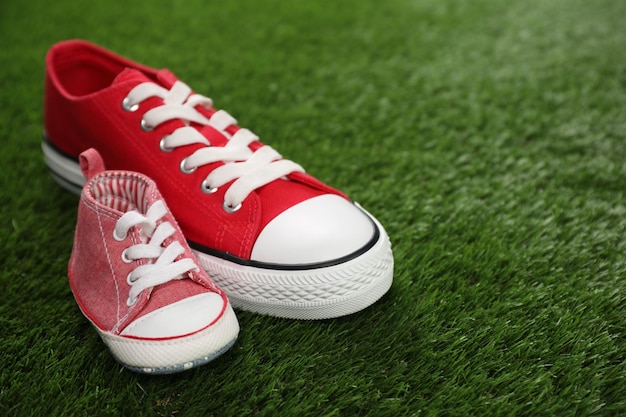 Grote en kleine schoenen op groen gras voor tekst