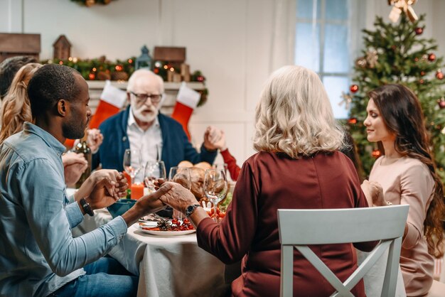 grote familie die samen bidt voor het kerstdiner