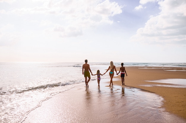 Grote familie hand in hand en staande in de buurt van de zee. zomervakantie