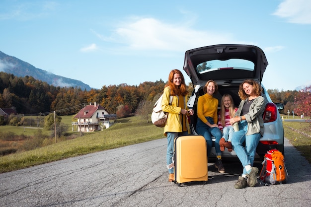 Grote familie-uitstapje - gelukkige meisjes reizen met de auto. mama met dochters in de koffer