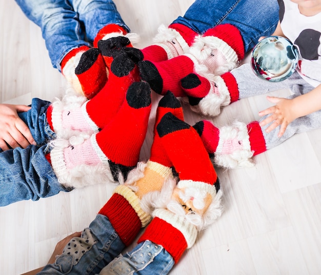 Grote familie van vader, moeder, zus, broer en baby in kerstsokken