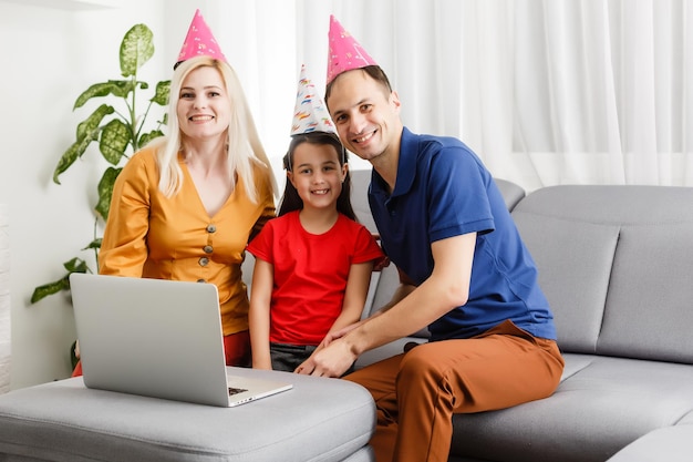 Grote familie viert verjaardag online. moeder vader kinderen thuis laptop video-oproep zelfisolatie. feest nieuwe technologie gadgets. coronavirus in quarantaine.