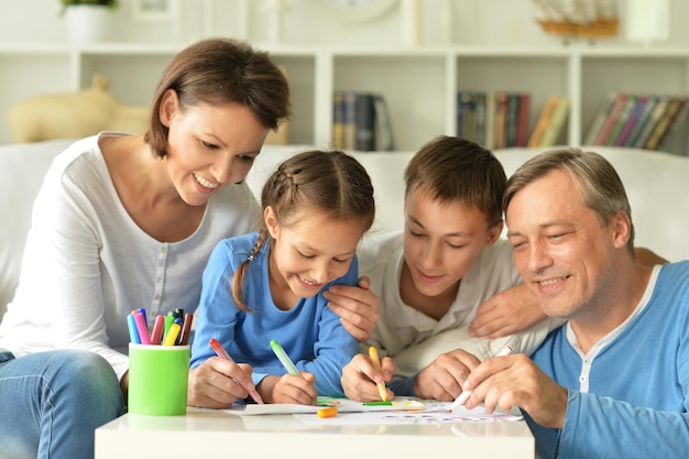 Grote gelukkige familie die thuis samen tekent, veel plezier