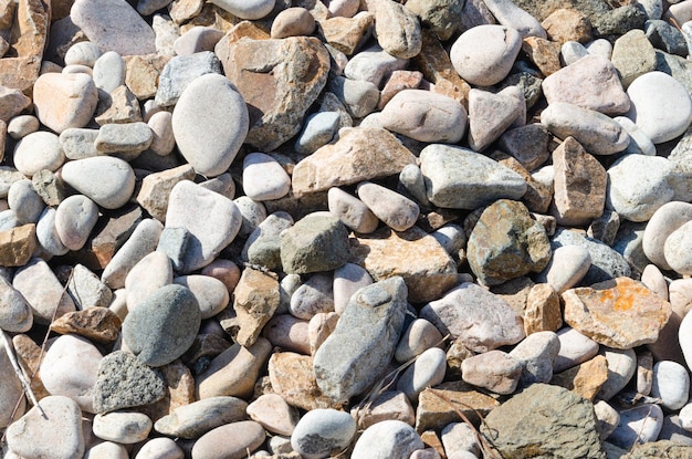 Grote gladde stenen aan de kust De achtergrond is gemaakt van kiezelstenen