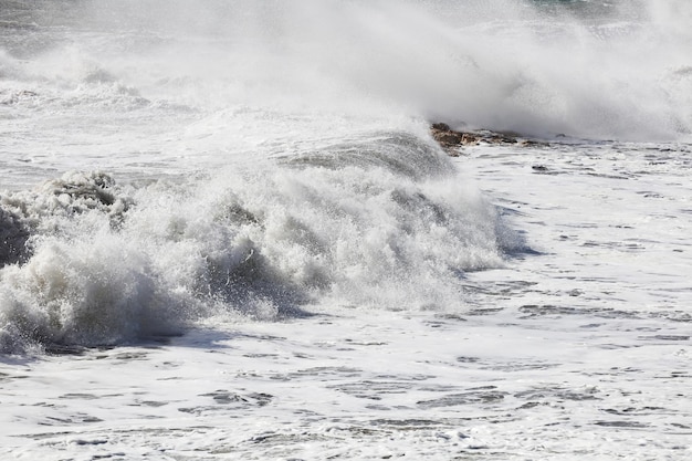 Grote golven breken op de kust met witte forma