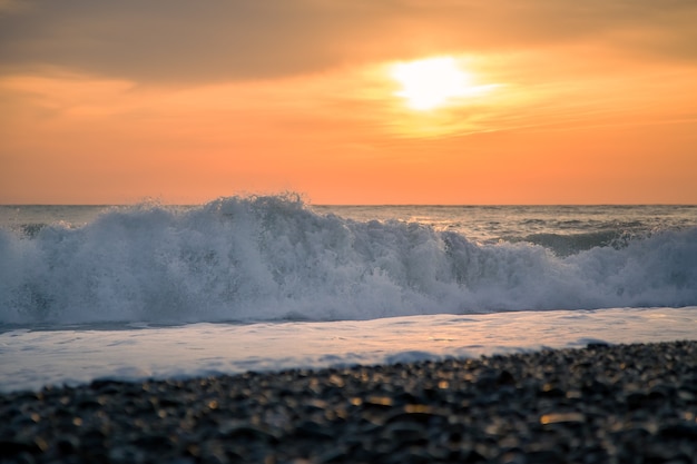 Grote golven en zonsondergang aan de kust, romantische avond