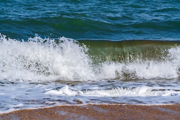 Grote golven spetteren op het strand