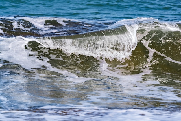 Grote golven spetteren op het strand