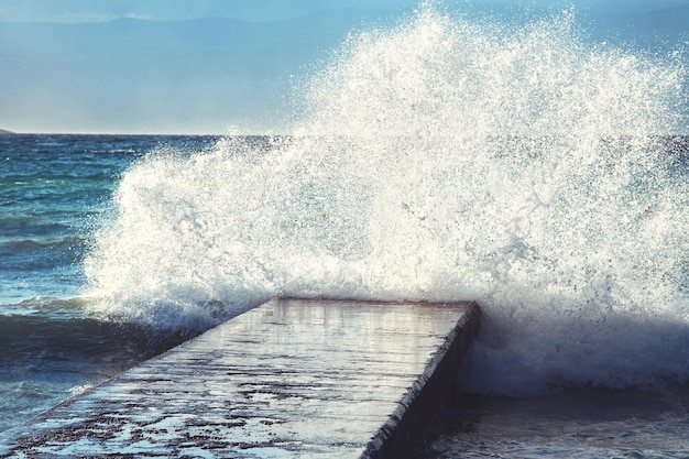 Grote golven verpletteren op stenen pier bij stormachtig weer