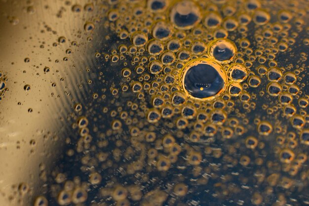 Foto grote gouden waterdruppel op donkerblauwe achtergrond