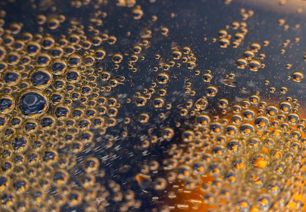 Foto grote gouden waterdruppel op donkerblauwe achtergrond