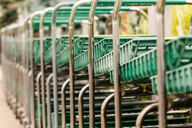 Grote groene winkelwagen op een rij.