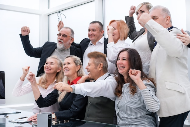 Grote groep gelukkige medewerkers die hun succes tonen