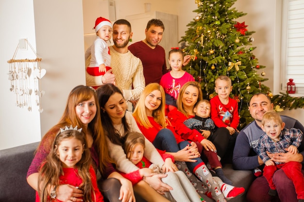 Grote groep kinderen met ouders nemen foto met Kerstmis. Fijne tijd samen, vrienden vieren kersttijd