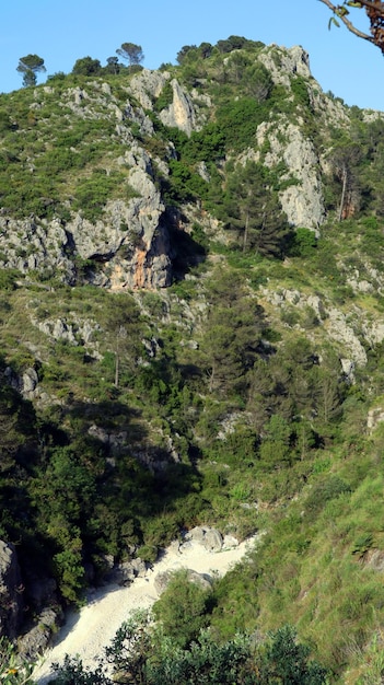 Grote grot in de rots, driehoekige ingang naar een donkere grot, de bergen van Spanje, Alicante