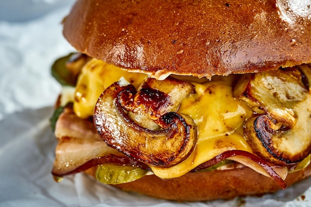 Grote hamburger met champignons kaas spek op wit perkament Closeup selectieve focus