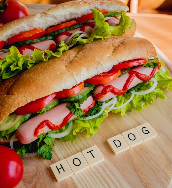 Grote hotdog met groenten op tafel.