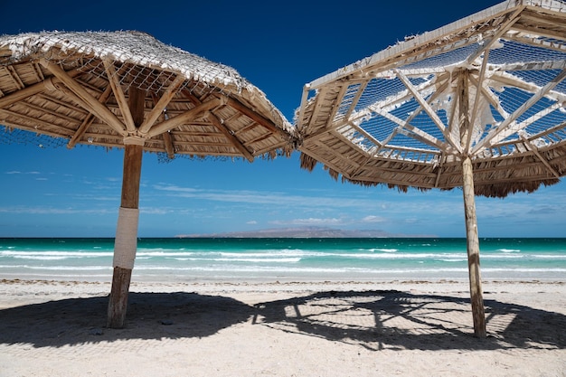 Grote houten parasols bij Playa El Tecolote bij La Paz Mexico