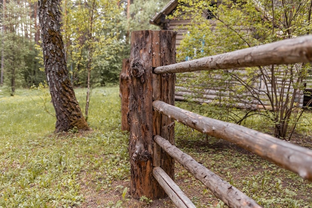 Grote houten schuttingpalen die een oud houten huis in het bos omsluiten Hoe mensen huizen bouwden