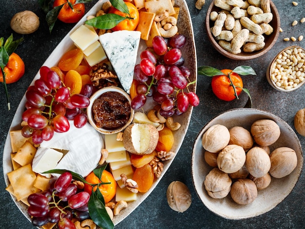 Grote kaasplank met amuse assortiment Druivenkaas noten jam en brood