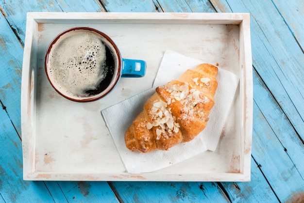 Foto grote koffiemok, croissant en krant