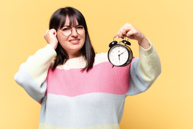 Grote maten mooie vrouw met een wekker