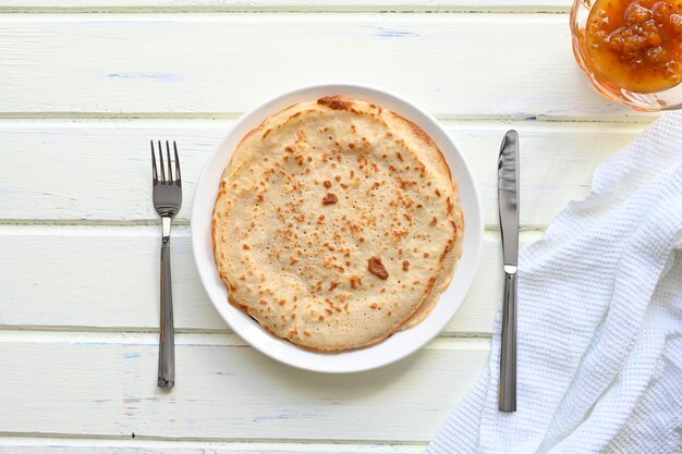 Grote pannenkoeken met jam op witte achtergrond.