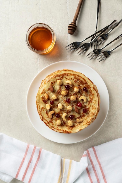 Foto grote pannenkoeken op een lichte stenen achtergrond worden geserveerd door vrouwelijke kok bovenaanzicht thuis koken pasen