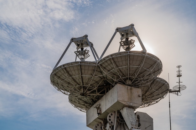 Grote paraboloische antennes tegen de blauwe hemel met wolken