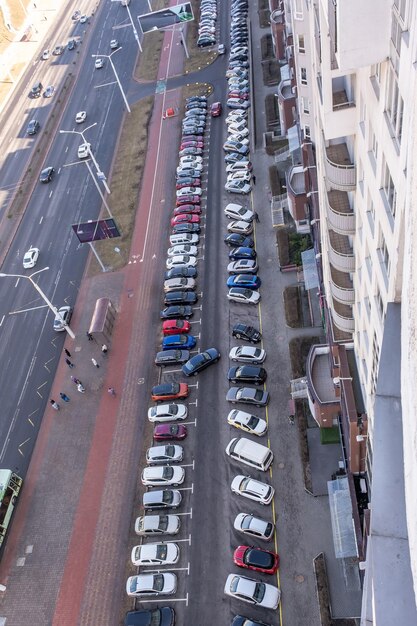 Grote parkeerplaats voor auto's voor een woongebouw met meerdere verdiepingen, zicht van boven