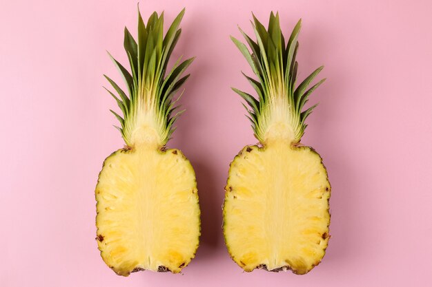 Grote rijpe fruitananas op een felroze tafel. zomer. bovenaanzicht.