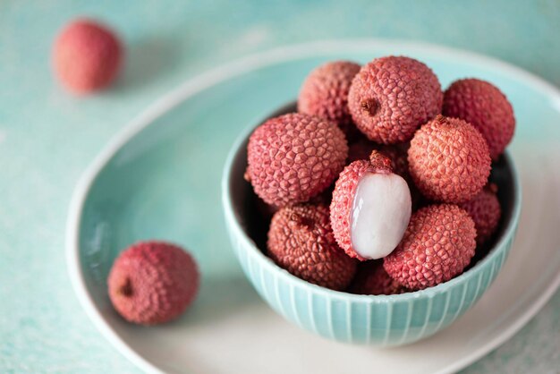 Grote rijpe lychees fruit in een turquoise kom, close-up