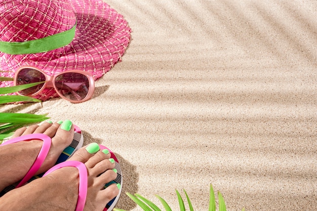 Grote ronde roze zomerhitte, met zonnebril op strandzand, bovenaanzicht, kopieerruimte