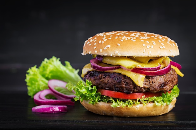 Grote sandwich hamburger burger met rundvlees tomaten kaas ingelegde komkommer en rode ui