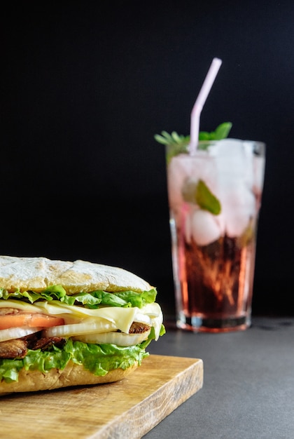 Grote sandwich met roze cocktail drinken