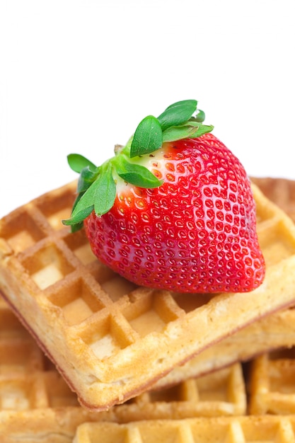 Foto grote sappige rijpe aardbeien en wafels die op wit worden geïsoleerd