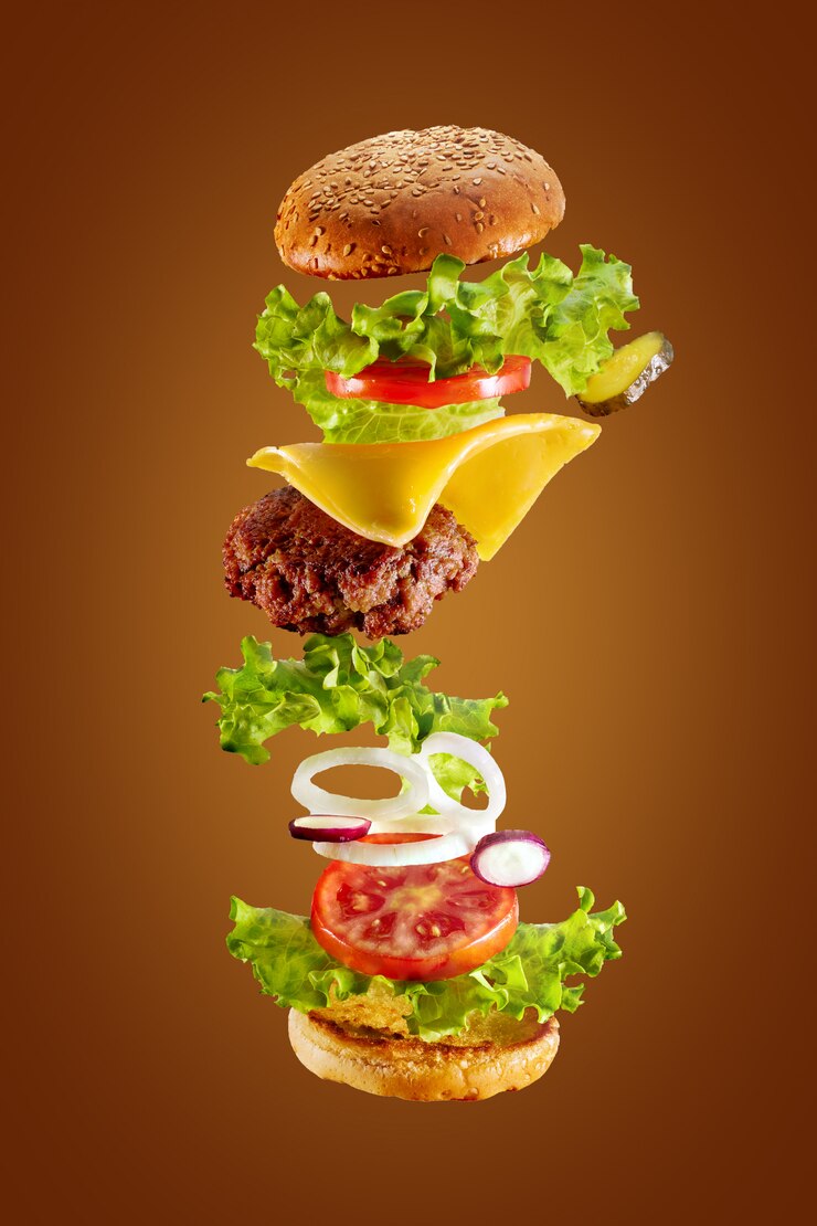 Grote smakelijke zelfgemaakte hamburger met vliegende ingrediënten op witte achtergrond. Geïsoleerd.