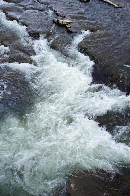 Grote snelle rivier verticaal beeld Koud water dat stroomt en schuim creëert