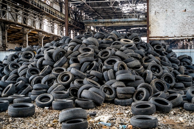 Grote stapel autobanden op de kapotte fabriek.