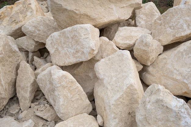 Grote stapel van grote zandstenen die op grond van bouwwerf leggen.